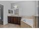 Bathroom featuring double sink vanity, large soaking tub, tile floors, and tiled backsplash at 491 Majestic Gardens Blvd, Winter Haven, FL 33880