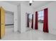 Bedroom with tile flooring, mirrored closet doors, red curtains, and ceiling fan at 491 Majestic Gardens Blvd, Winter Haven, FL 33880