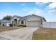 Charming home showcasing the garage, driveway, stone accents, and mature landscaping at 491 Majestic Gardens Blvd, Winter Haven, FL 33880