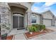 Inviting front entry with stone pillars and manicured landscaping with mulch and lush foliage at 491 Majestic Gardens Blvd, Winter Haven, FL 33880