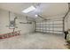Spacious two car garage featuring shelving, work lighting and neutral color palette at 491 Majestic Gardens Blvd, Winter Haven, FL 33880