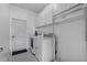 Laundry room features white washer and dryer, overhead cabinets, and a door to outside at 491 Majestic Gardens Blvd, Winter Haven, FL 33880