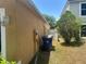 Side yard showing the exterior of the home, utilities, and some greenery at 5030 Silver Thistle Ln, St Cloud, FL 34772