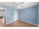 Bright bedroom featuring laminate floors, a ceiling fan, and ample closet space at 5210 Silver Thistle Ln, St Cloud, FL 34772