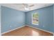 Clean bedroom with wood-look flooring, ceiling fan, and window offering natural light at 5210 Silver Thistle Ln, St Cloud, FL 34772