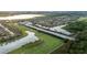 An aerial view features community homes next to a water feature and lush green spaces at 5253 Pebble Beach Blvd, Winter Haven, FL 33884