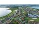 This aerial view showcases homes near a lake, golf course and lush green spaces at 5253 Pebble Beach Blvd, Winter Haven, FL 33884