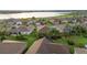 An aerial view showcases single Gathering homes in a Primary-planned community near a lake at 5253 Pebble Beach Blvd, Winter Haven, FL 33884