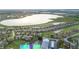 Aerial view of neighborhood homes by a large lake and golf course with beautiful landscaping at 5253 Pebble Beach Blvd, Winter Haven, FL 33884
