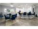 Open-concept dining area with kitchen access, a glass table, and stylish blue chairs at 5253 Pebble Beach Blvd, Winter Haven, FL 33884