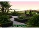 Serene view of the East Gardens with manicured hedges, brick pathways, and water views at 5253 Pebble Beach Blvd, Winter Haven, FL 33884