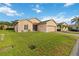 Well-maintained lawn with a charming single-story home and brick driveway at 5253 Pebble Beach Blvd, Winter Haven, FL 33884