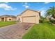 Well-maintained single-story home featuring a brick driveway and lush green lawn at 5253 Pebble Beach Blvd, Winter Haven, FL 33884