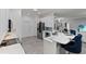 Well-lit kitchen featuring white cabinets, stainless steel appliances, and a breakfast bar at 5253 Pebble Beach Blvd, Winter Haven, FL 33884