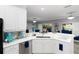 Bright kitchen with white cabinets, quartz countertops, and stainless steel sink with window views at 5253 Pebble Beach Blvd, Winter Haven, FL 33884
