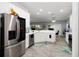 Bright kitchen features stainless steel refrigerator, white cabinets, and gray flooring at 5253 Pebble Beach Blvd, Winter Haven, FL 33884