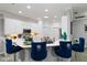 Stylish kitchen with white cabinets, quartz countertops, and bar seating with decorative blue chairs at 5253 Pebble Beach Blvd, Winter Haven, FL 33884