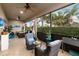 Relaxing screened lanai with wicker chairs, tile flooring, and serene views of tropical foliage at 5253 Pebble Beach Blvd, Winter Haven, FL 33884