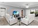 Bright living room featuring tile flooring, a TV, and comfortable white sofas at 5253 Pebble Beach Blvd, Winter Haven, FL 33884