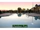 An outdoor pool with a seating area offers relaxation with sunset views in the background at 5253 Pebble Beach Blvd, Winter Haven, FL 33884