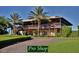 The exterior of the community pro shop features a covered porch and lush landscaping at 5253 Pebble Beach Blvd, Winter Haven, FL 33884