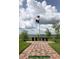 Beautifully landscaped Veterans Memorial featuring flags, stone monuments, and water views at 5253 Pebble Beach Blvd, Winter Haven, FL 33884