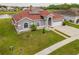 Areal shot of single Gathering home with lake view, green grass and a brick red roof at 5418 Crepe Myrtle Cir, Kissimmee, FL 34758