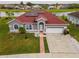 Beautiful home with a red roof, green grass, attached garage and solar panels at 5418 Crepe Myrtle Cir, Kissimmee, FL 34758