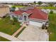 Single Gathering home with green lawn, brick red roof, and solar panels sits next to a lake at 5418 Crepe Myrtle Cir, Kissimmee, FL 34758