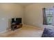 Functional bedroom with neutral tones, carpet, a TV, and a window at 5418 Crepe Myrtle Cir, Kissimmee, FL 34758