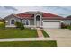 Charming single Gathering home featuring a well-manicured lawn and solar panels on a red roof at 5418 Crepe Myrtle Cir, Kissimmee, FL 34758