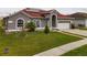 Beautiful single Gathering home with a red roof, green grass and an attached garage at 5418 Crepe Myrtle Cir, Kissimmee, FL 34758