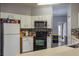 Cozy kitchen featuring white cabinets, a black backsplash, and a range at 5418 Crepe Myrtle Cir, Kissimmee, FL 34758
