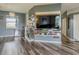 Open-concept living room featuring hardwood floors and a mounted big screen TV at 5418 Crepe Myrtle Cir, Kissimmee, FL 34758