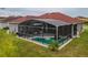 Screened-in pool and patio area in a well-maintained backyard with lawn at 5418 Crepe Myrtle Cir, Kissimmee, FL 34758
