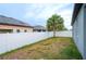 Fenced backyard with healthy green grass and a tropical tree at 5876 Bar Ranch Rd, St Cloud, FL 34771