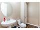 Elegant half bathroom with modern fixtures, a pedestal sink, and a decorative mirror at 5876 Bar Ranch Rd, St Cloud, FL 34771