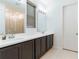 Bathroom featuring a double vanity with dark cabinets, mirrors, and a glass-enclosed shower at 5876 Bar Ranch Rd, St Cloud, FL 34771