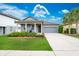 Charming single-story home featuring a well-manicured lawn, mature palm trees, and an attached two-car garage at 5876 Bar Ranch Rd, St Cloud, FL 34771