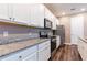 Contemporary kitchen with white cabinetry, granite countertops, stainless steel appliances, and wood flooring at 5876 Bar Ranch Rd, St Cloud, FL 34771