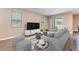 Cozy living room featuring a plush sofa, a large television, and ample natural light from large windows at 5876 Bar Ranch Rd, St Cloud, FL 34771