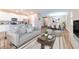 Open-concept living room featuring a modern kitchen with stainless appliances and a dining area with stylish furnishings at 5876 Bar Ranch Rd, St Cloud, FL 34771