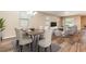 Open-concept living room and dining area with wood floors, comfortable seating, and large windows at 5876 Bar Ranch Rd, St Cloud, FL 34771