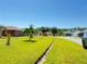 Exterior front lawn view with a lush green lawn and mature trees; a neighborhood street is visible in the background at 622 Dromedary Ct, Kissimmee, FL 34759