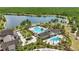 Stunning aerial view of the community pool, splash pad, lake, and amenities, surrounded by lush greenery and landscaping at 8378 Randal Park Blvd, Orlando, FL 32832