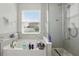 Bright bathroom showcases a soaking tub with window view and a glass-enclosed shower at 8378 Randal Park Blvd, Orlando, FL 32832