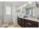 Bright bathroom featuring double vanity with dark wood cabinets and white countertop, plus a separate glass enclosed shower at 8378 Randal Park Blvd, Orlando, FL 32832