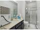 Bright bathroom featuring a glass-enclosed shower, modern vanity, and neutral decor at 8378 Randal Park Blvd, Orlando, FL 32832