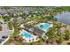 Aerial view of neighborhood pool, splash pad, and clubhouse, bordered by palm trees and a lake at 8378 Randal Park Blvd, Orlando, FL 32832
