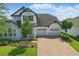 Charming two-story home with stone accents, a three-car garage, and beautiful landscaping at 8378 Randal Park Blvd, Orlando, FL 32832